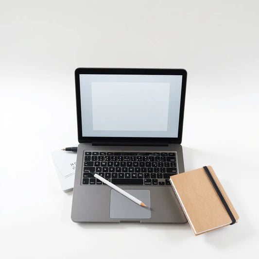 Laptop with digital coloring pages, stylus and blank sheets on a tidy desk