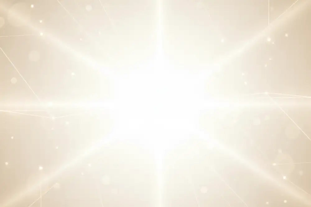 A radiant white light burst with glowing rays and soft bokeh particles.